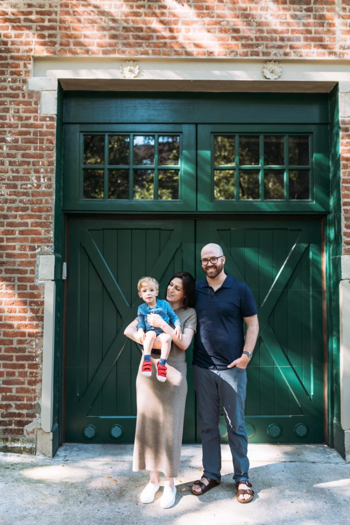 Family of three standing in cobblestone street in Brooklyn NYC photo session