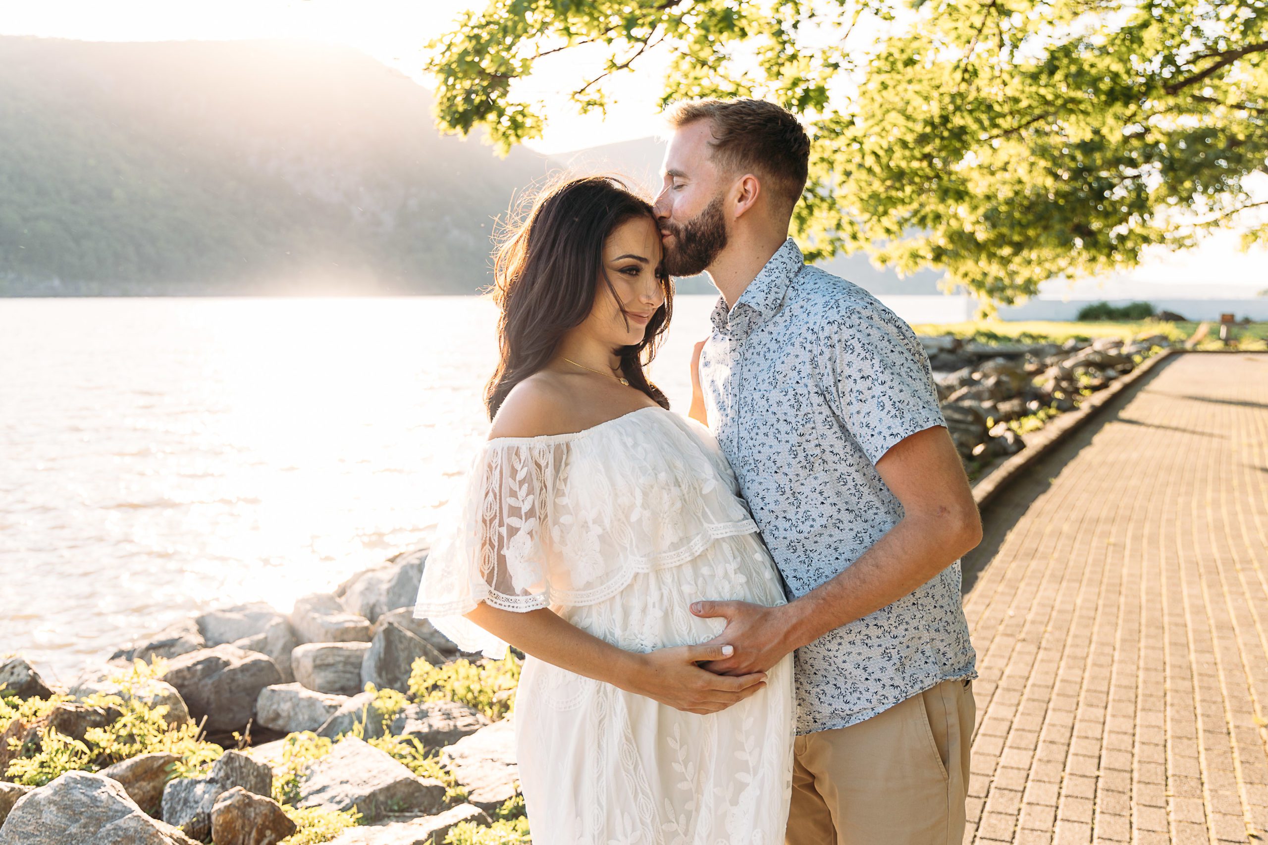Outdoor couple maternity photoshoot at the beach in beautiful white flowy white lace maternity dress