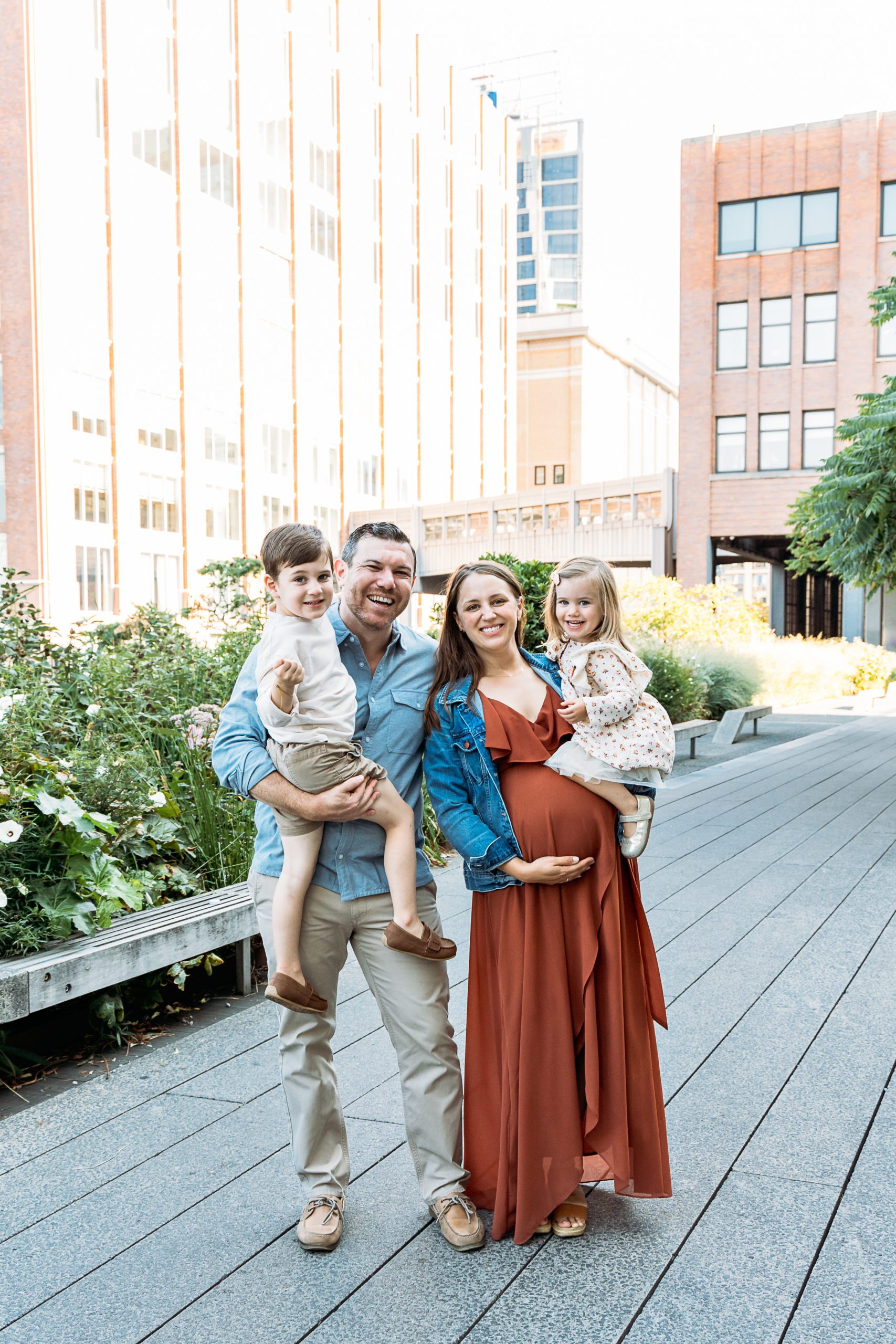Mother, Father, Son and Daughter are enjoying their outdoor fall family maternity photoshoot at Highline Park in NYC